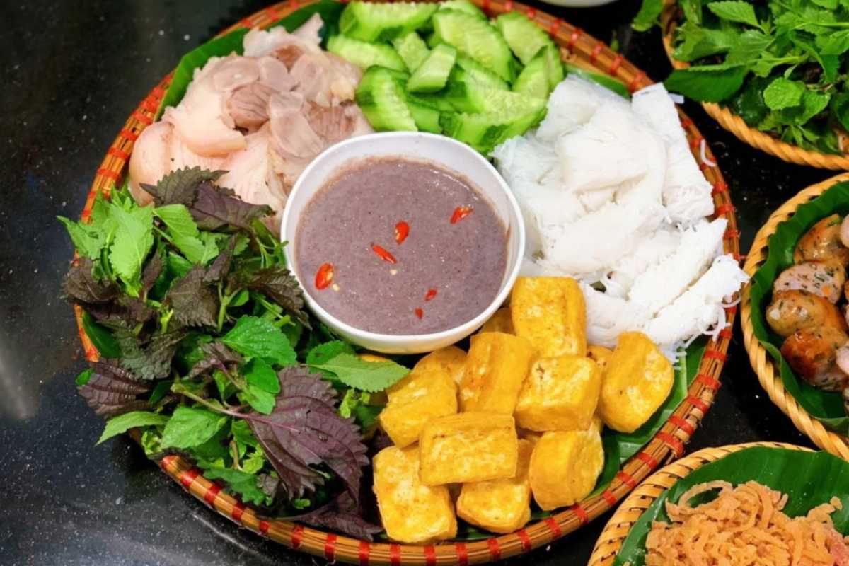 A full serving of bun dau mam tom is arranged on a traditional bamboo tray